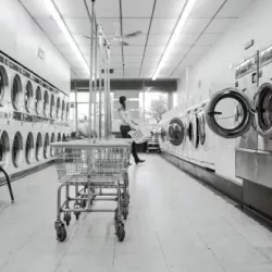 Imagen que muestra la exposición de maquinaria para lavandería industrial con un panel de texto promocional para Castilla y León